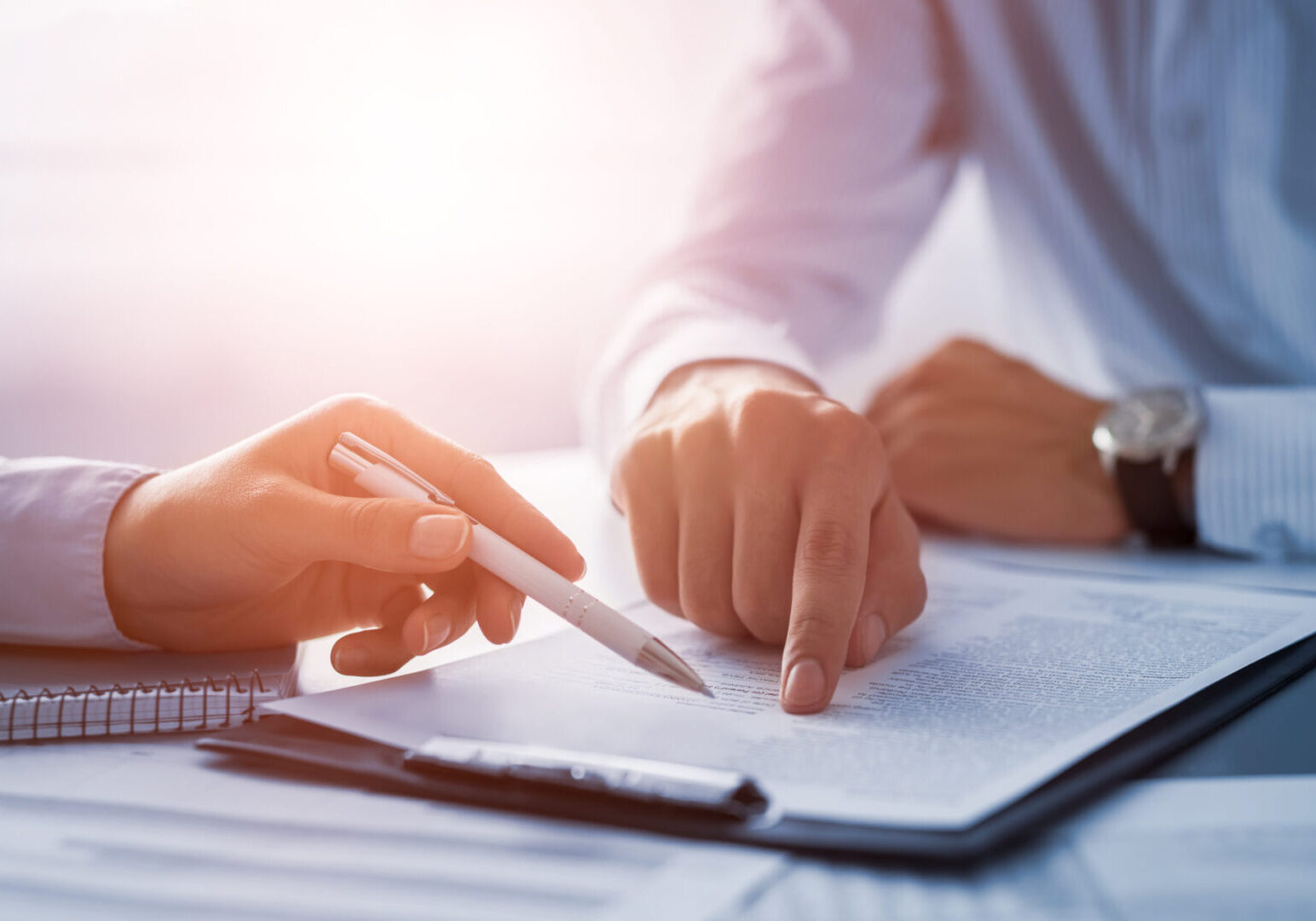 Business people negotiating a contract. Human hands working with documents at desk and signing contract.